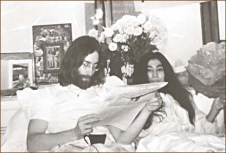 John Lennon reads a newspaper at the Bed-In