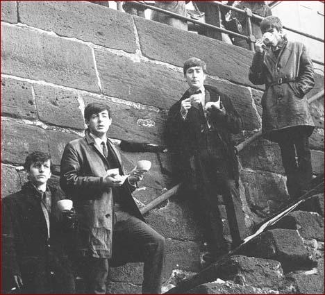 The Beatles enjoy a cup of tea Merseyside. Left to right: Ringo Starr, Paul McCartney, John Lennon, and George Harrison.
