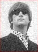 4: Polka Dot Hip: A sophisticated look for John Lennon in 1965, a while shirt with black polka dots under a black suit jacket. The Beatle makes his hip look complete with a pair of very cool sunglasses.