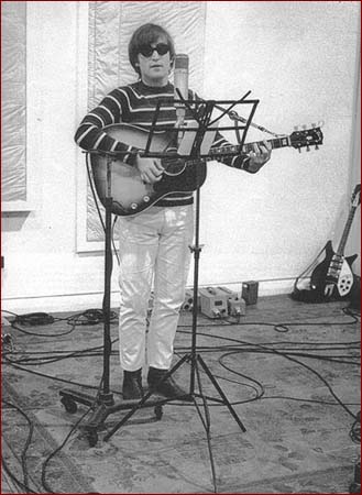 12: Studio Stripes: At London’s Abbey Road Studios in 1965, John Lennon pauses for a photo in casual white pants and a black and white horizontal striped lightweight sweater. He’s still sporting his trademark Beatle boots and cool shades.